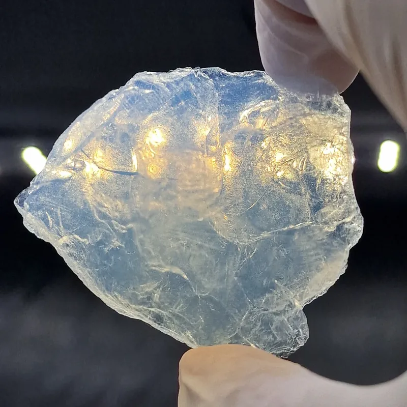 Morceau d’aérogel de silice translucide aux reflets bleus sur fond sombre